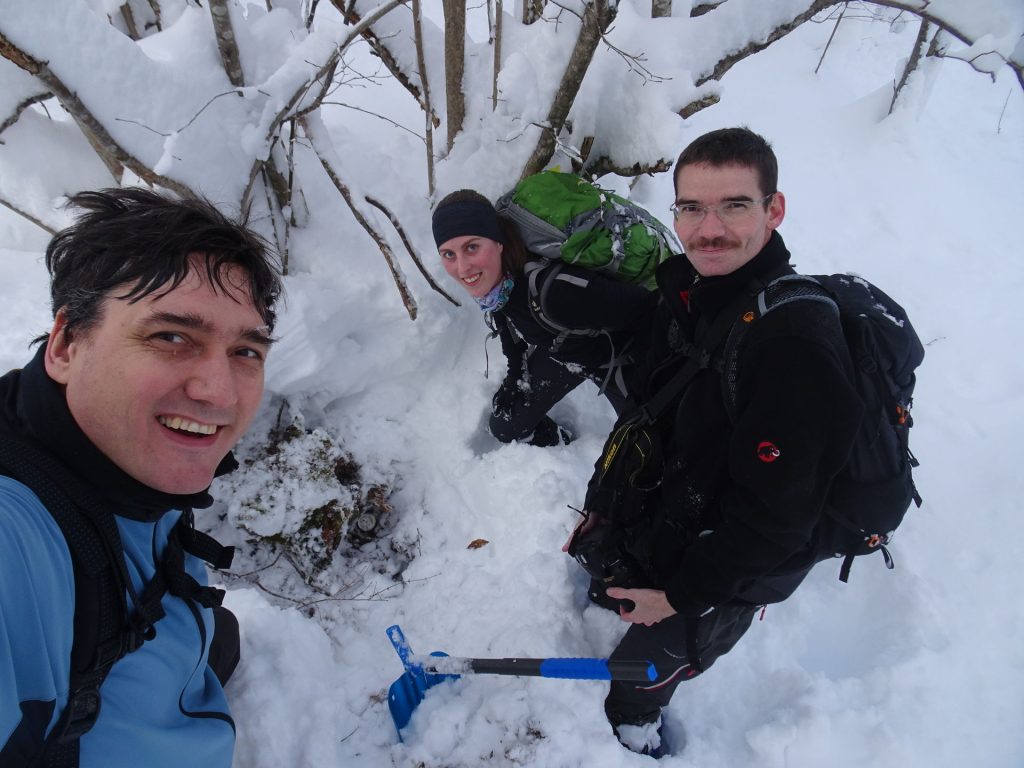 Veselje ekipe ob najdbi, zakladek se skriva tik nad špicem lopate